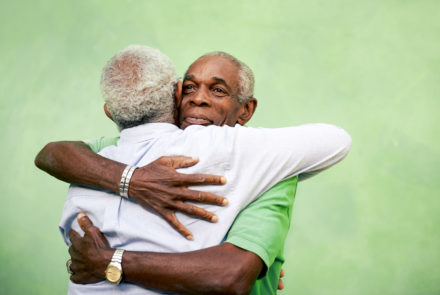 Old friends. Two older African American men hugging.